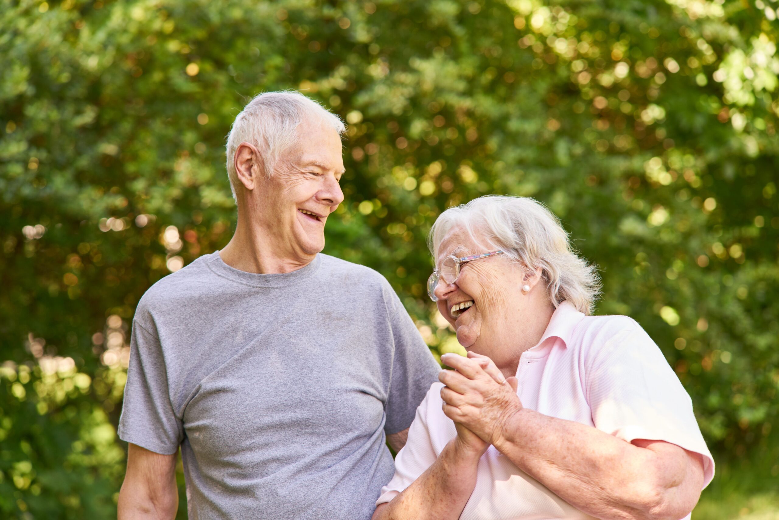 Senioren Paar lacht zusammen über einen Scherz beim Spaziergang im Sommer in der Natur